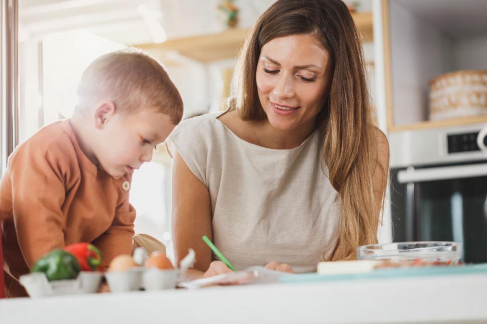 Free Image of Woman helping her son with homework in the kitchen 