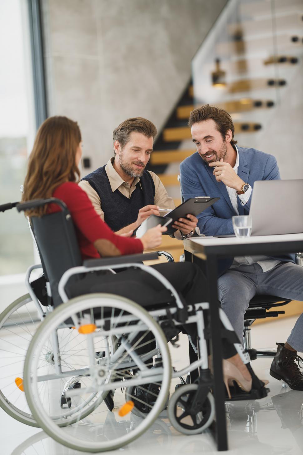 Free Image of Wheelchair-using woman with two male colleagues discussing a project 