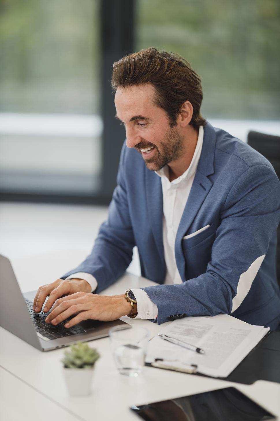 Free Image of Happy male executive working on laptop 