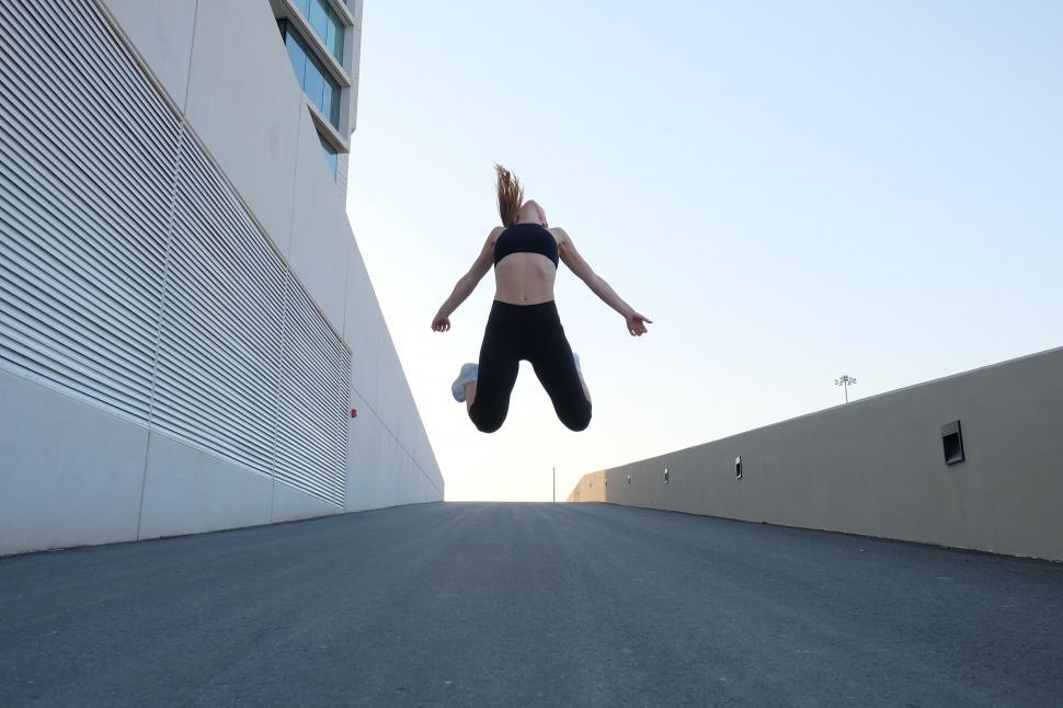 Free Image of Woman jumping outside a building 