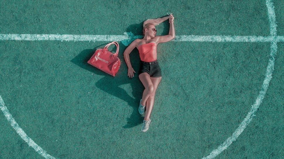 Free Image of Female fashion model lying and posing on football field 