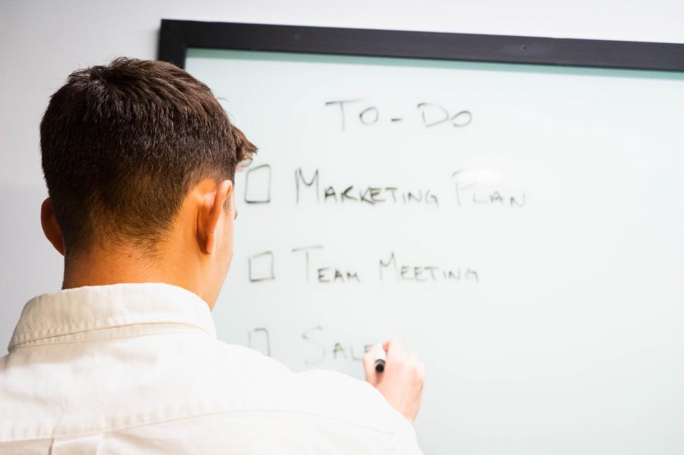 Free Image of Male executive writing plan and schedule on whiteboard 