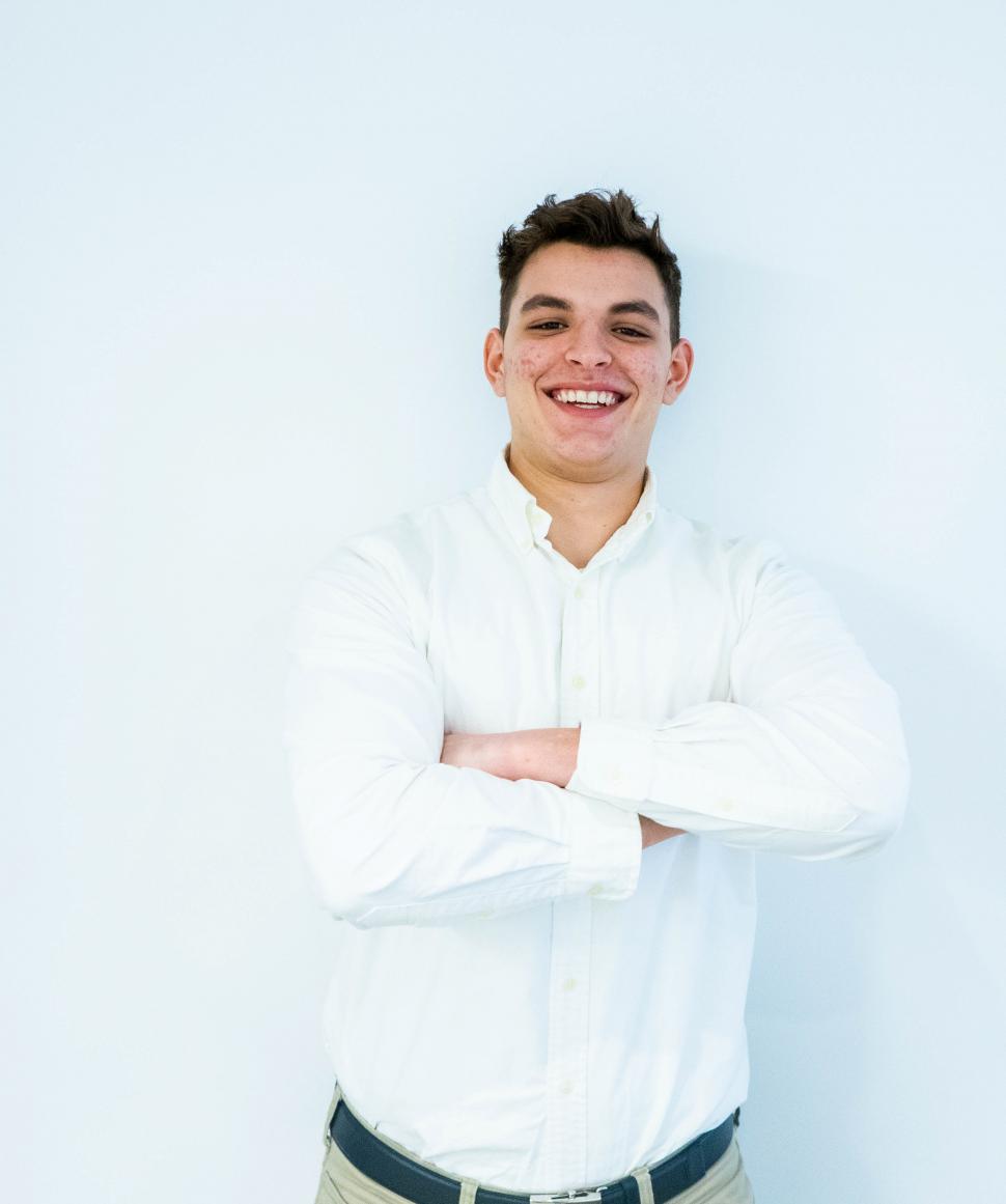 Free Image of Young man in white shirt smiling for camera 