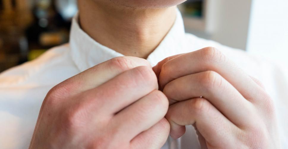 Free Image of Male hands on white shirt collars 