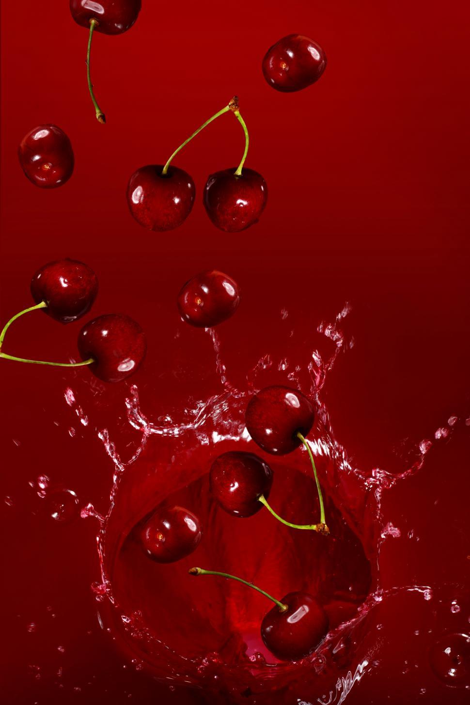 Free Image of Cherries falling into a splash of juice 