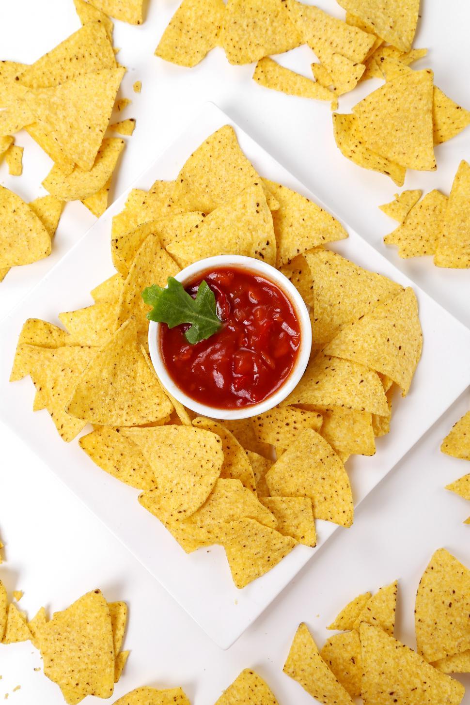 Free Image of Corn tortilla chips surround a plate with salsa 