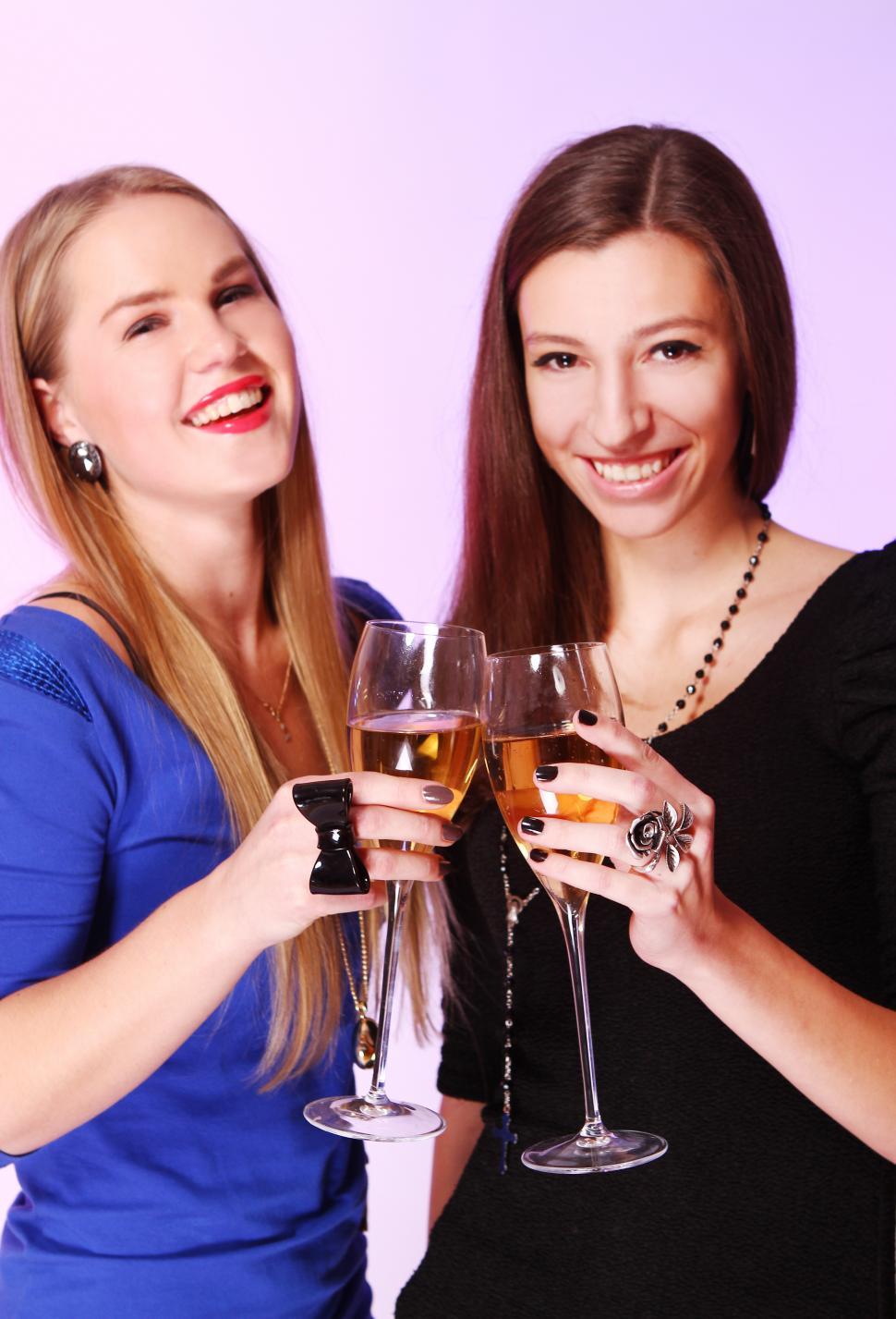 Free Image of Two happy girlfriends toast with colorful cocktails 