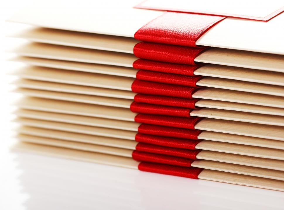 Free Image of Stack of gift envelopes with red bow 