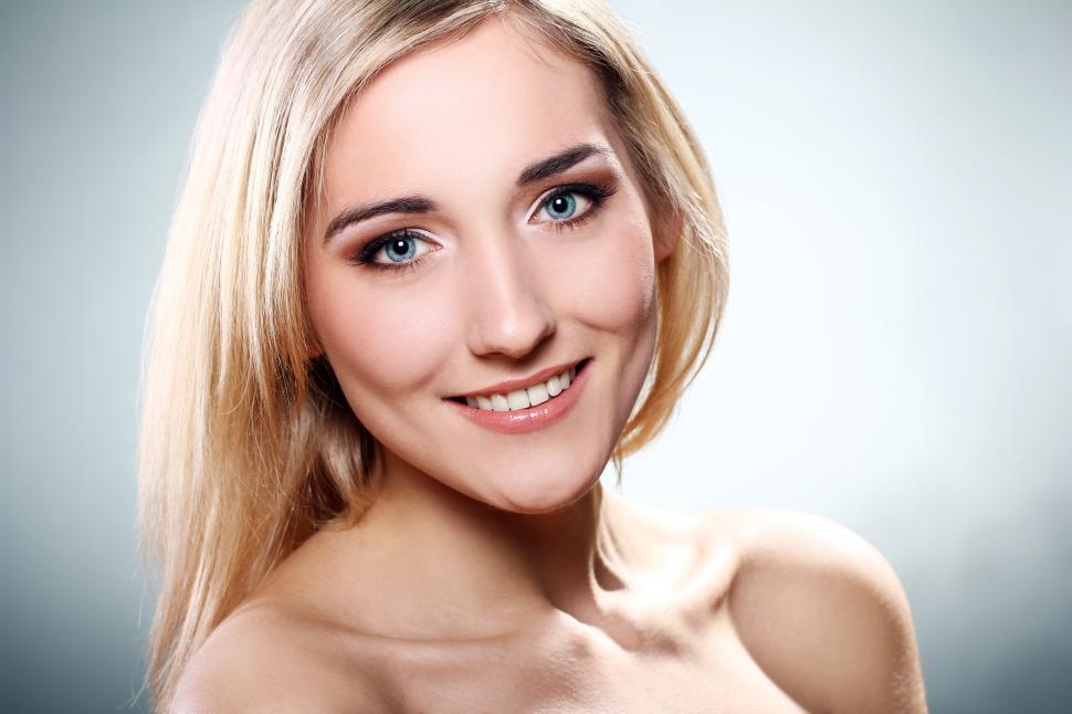 Free Image of Young woman smiling at camera, bright background 
