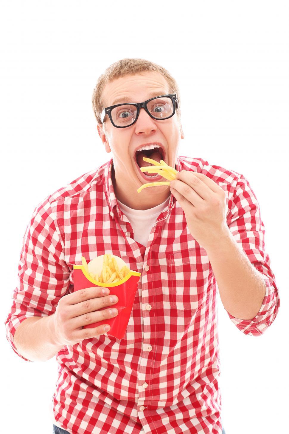 Free Image of Hungry guy scarfing french fries 