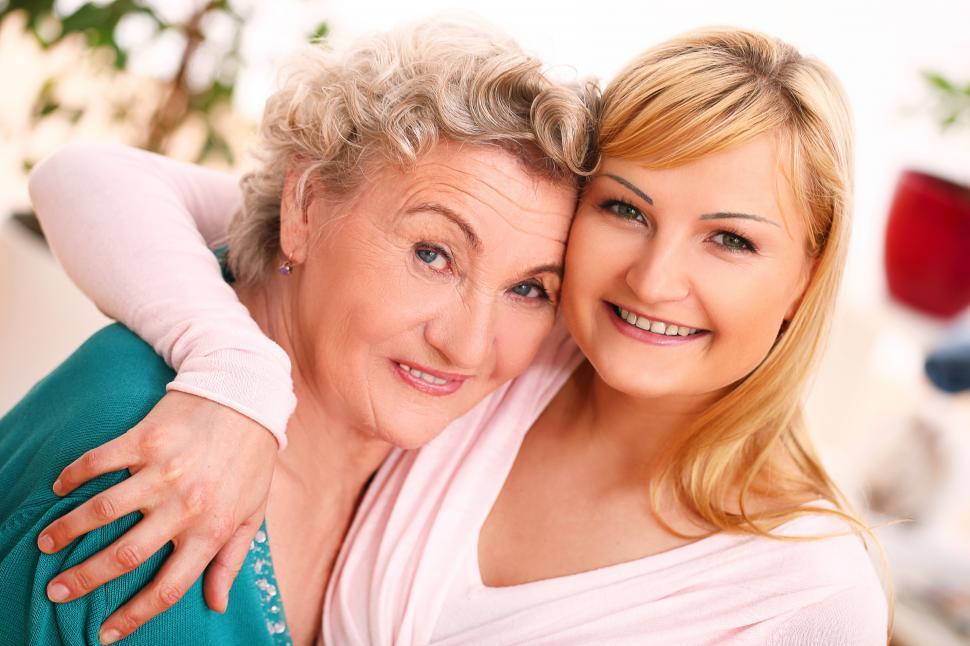 Free Image of Granddaughter and Grandmother embrace, looking at the camera 