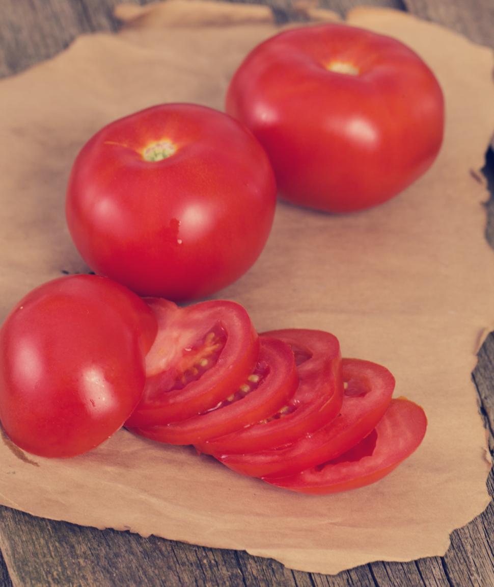 Free Image of Red tomatoes, sliced and whole, on the table 