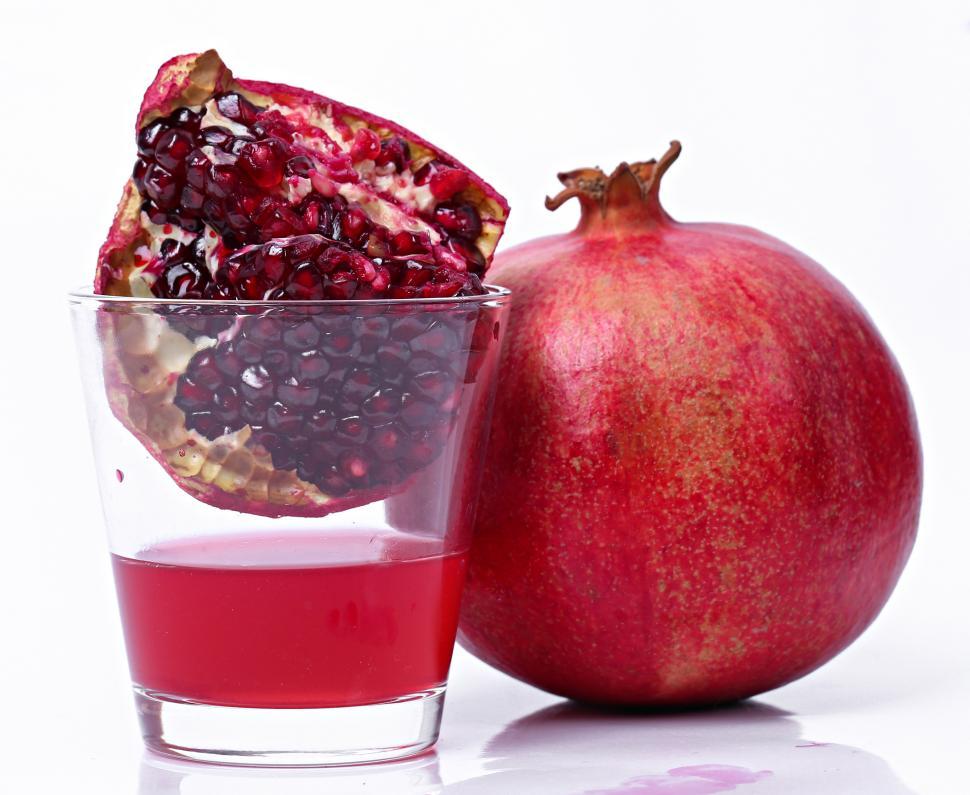 Free Image of Delicious pomegranate juice, with fruit, whole and quartered 