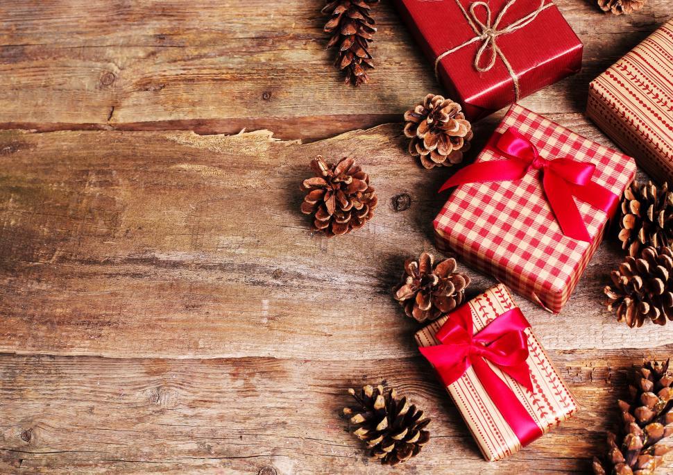 Free Image of Gifts and Pinecones on Wooden Background 