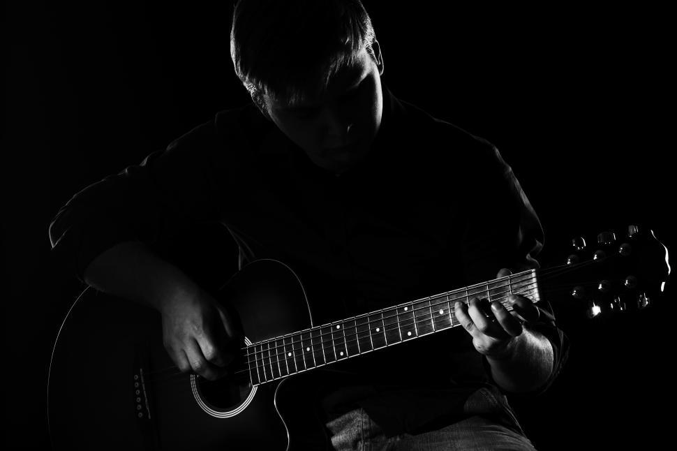 Free Image of Man with guitar in darkness, only highlighted 