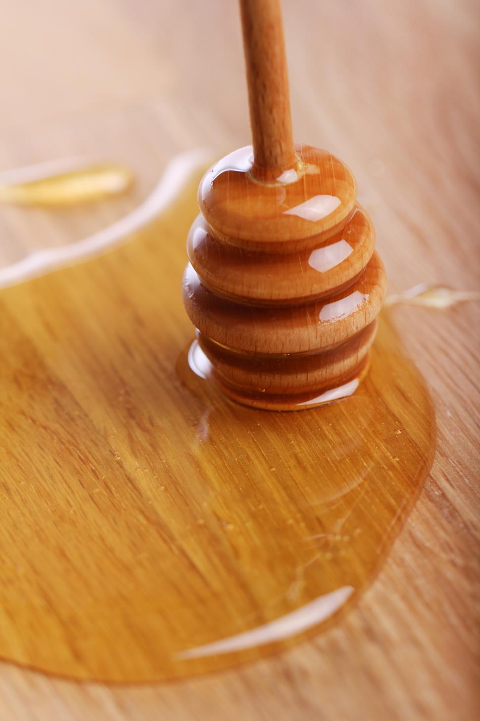 Free Image of Honey dipper and honey on the wooden table 