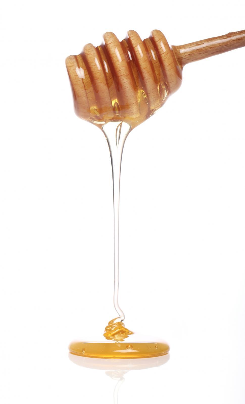 Free Image of Honey dripping from a wooden honey dipper 