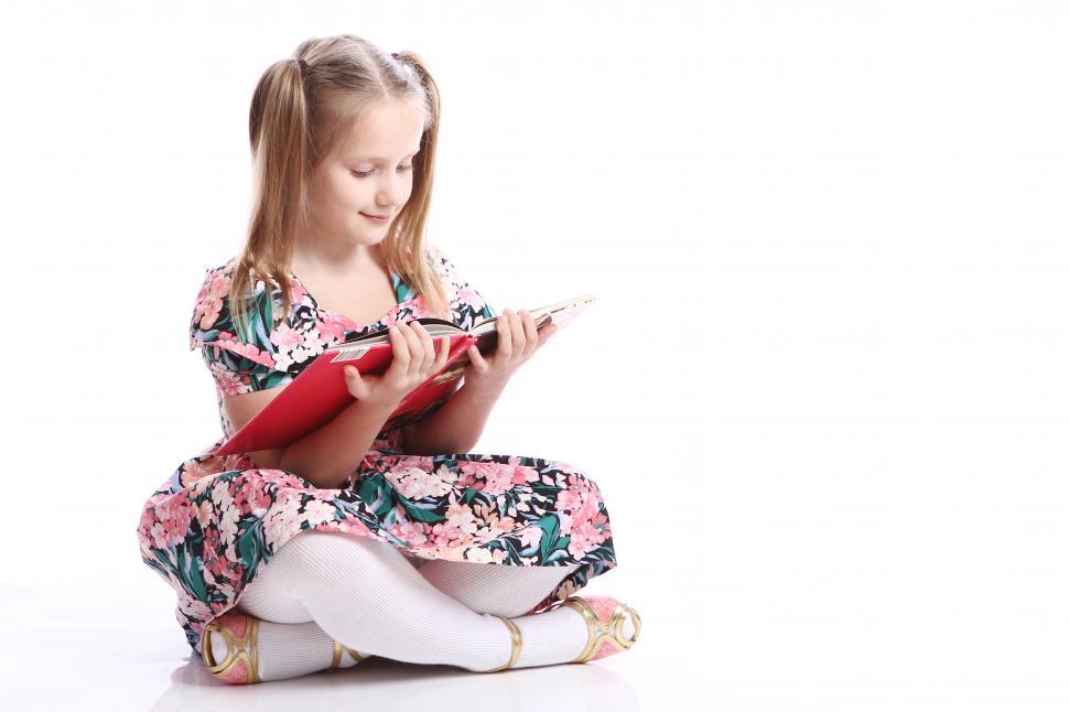 Free Image of Cute kid sitting and reading a big book 