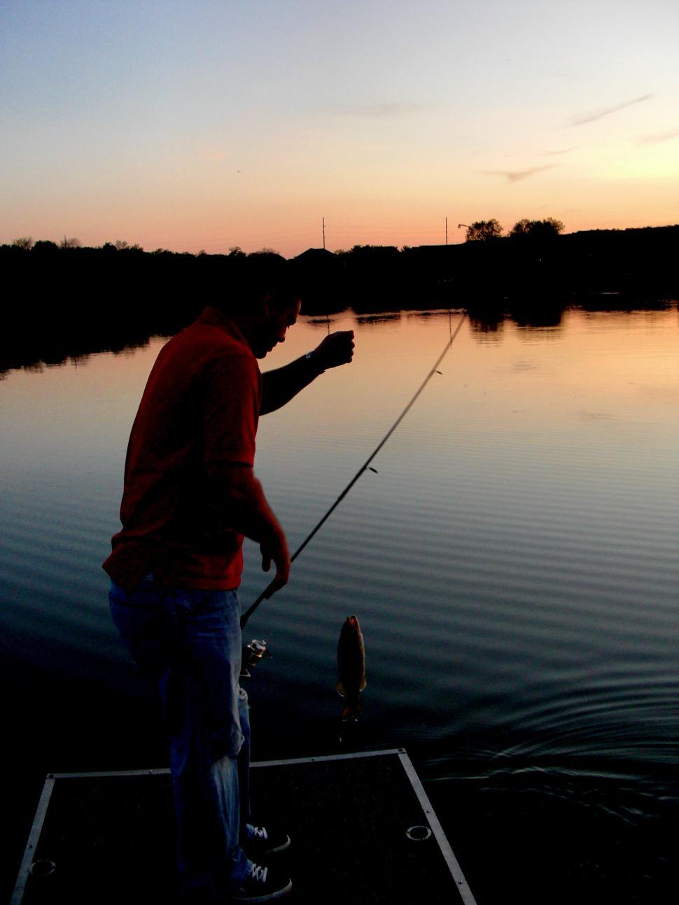 Free Image of Man Fishing on Lake at Sunset 