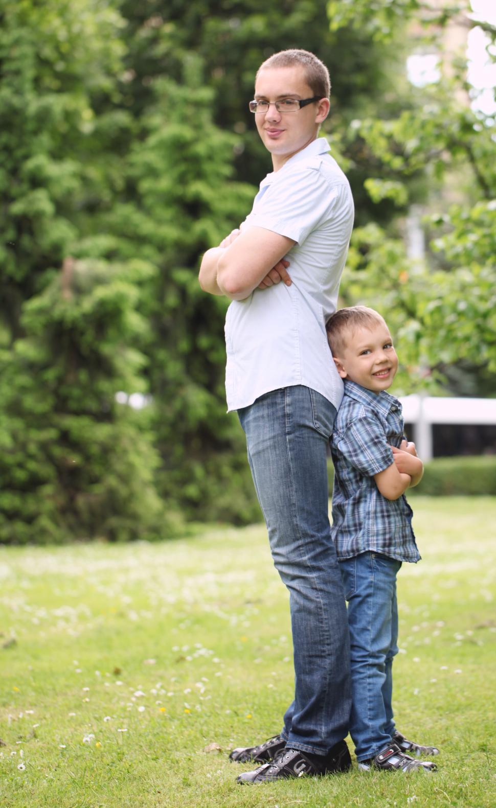 Free Image of Father and his son have fun in the park, standing back to back 