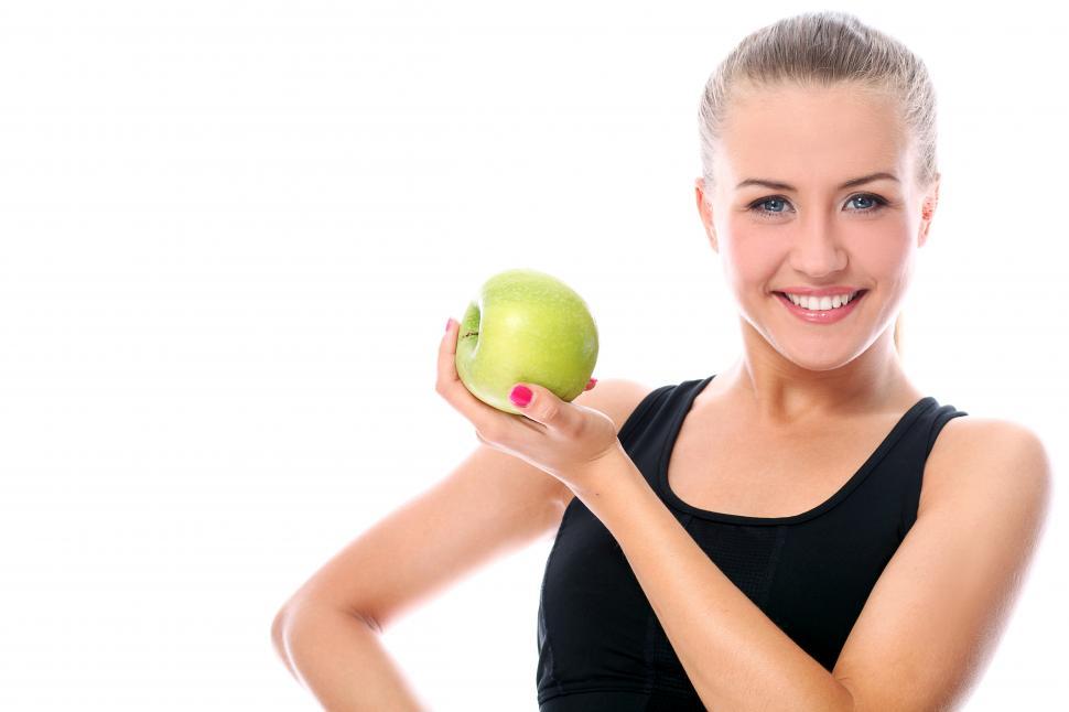 Free Image of Smiling healthy woman holding an green apple 