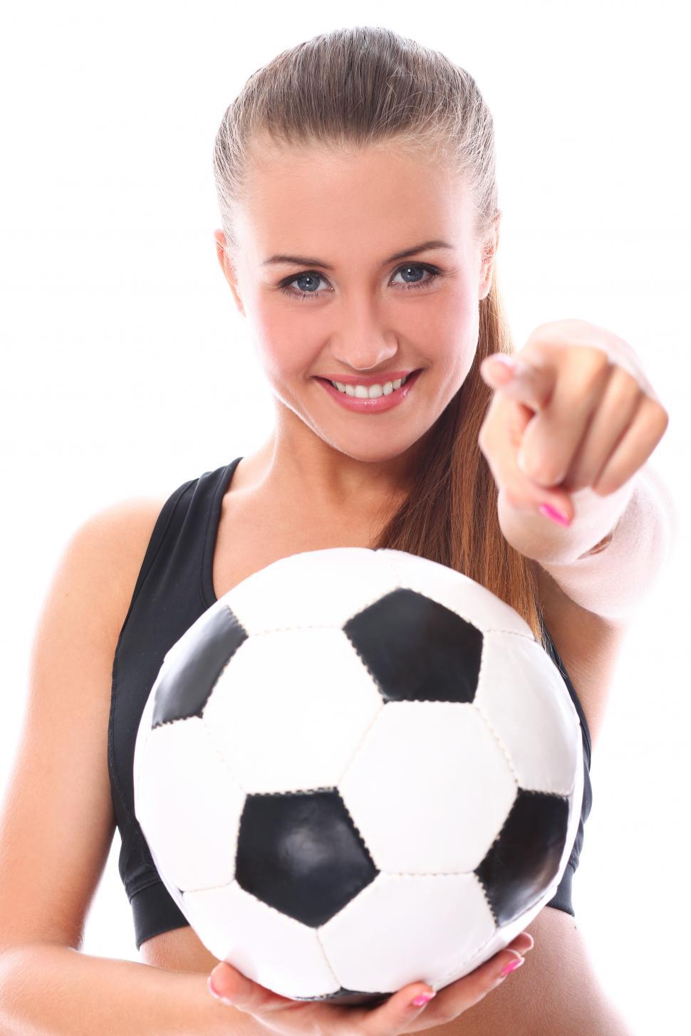 Free Image of Young girl with soccer ball, pointing at the viewer 