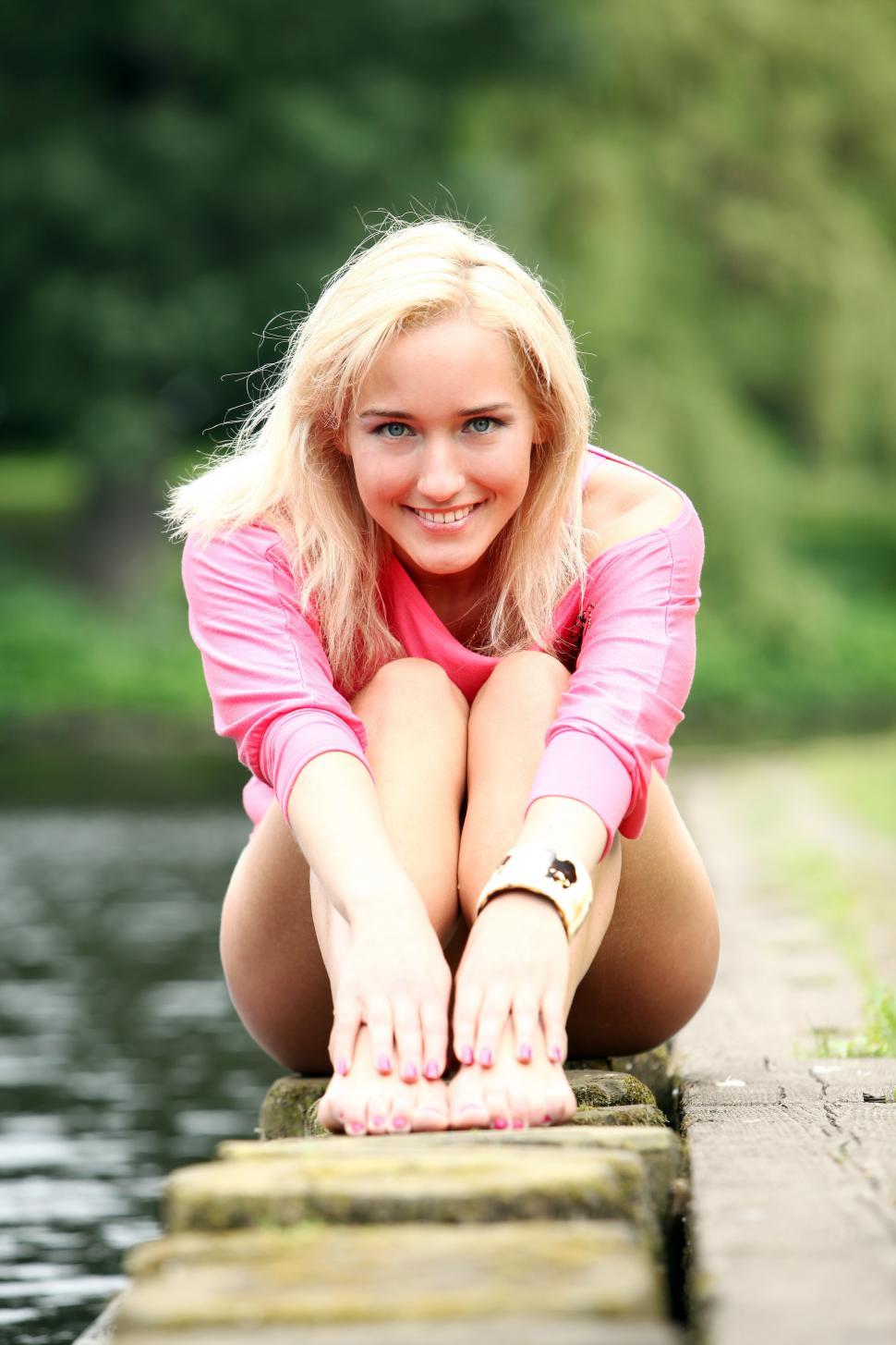 Free Image of Portrait of young woman by a canal, barefoot 