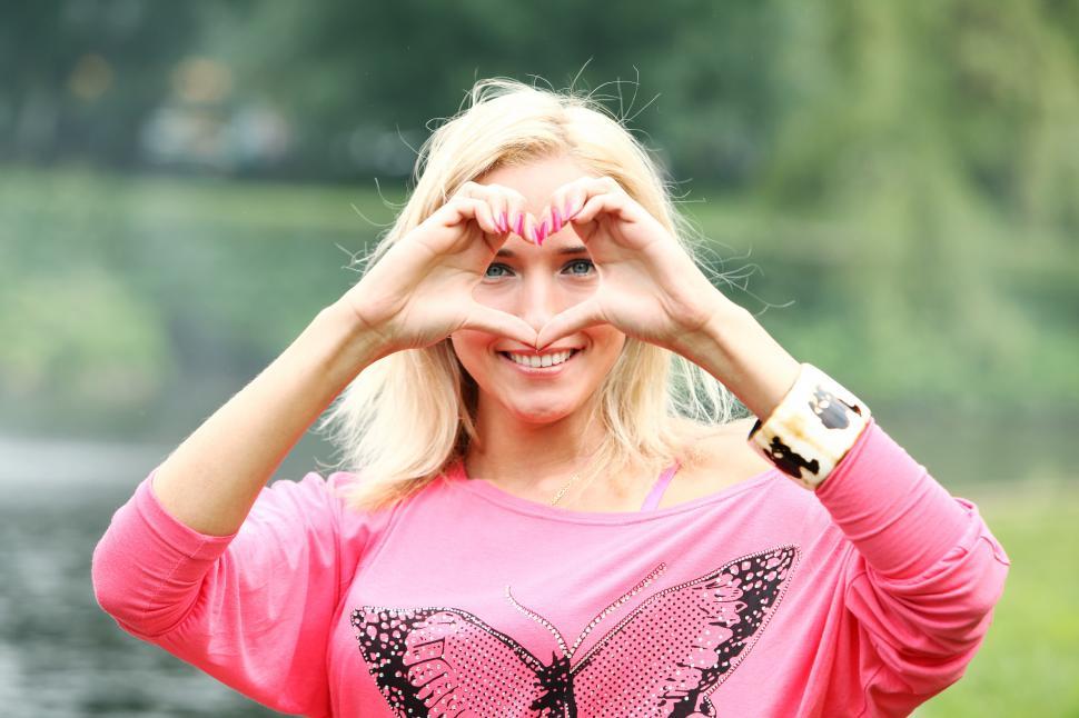Free Image of Happy blonde forming heart with her hands 
