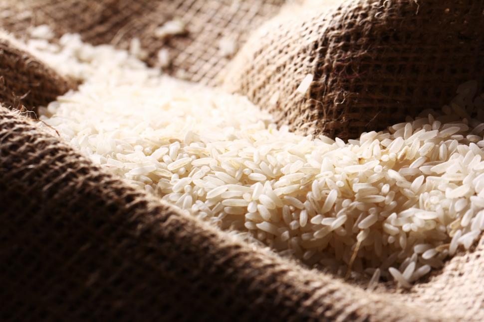 Free Image of White rice grains on burlap sack cloth 