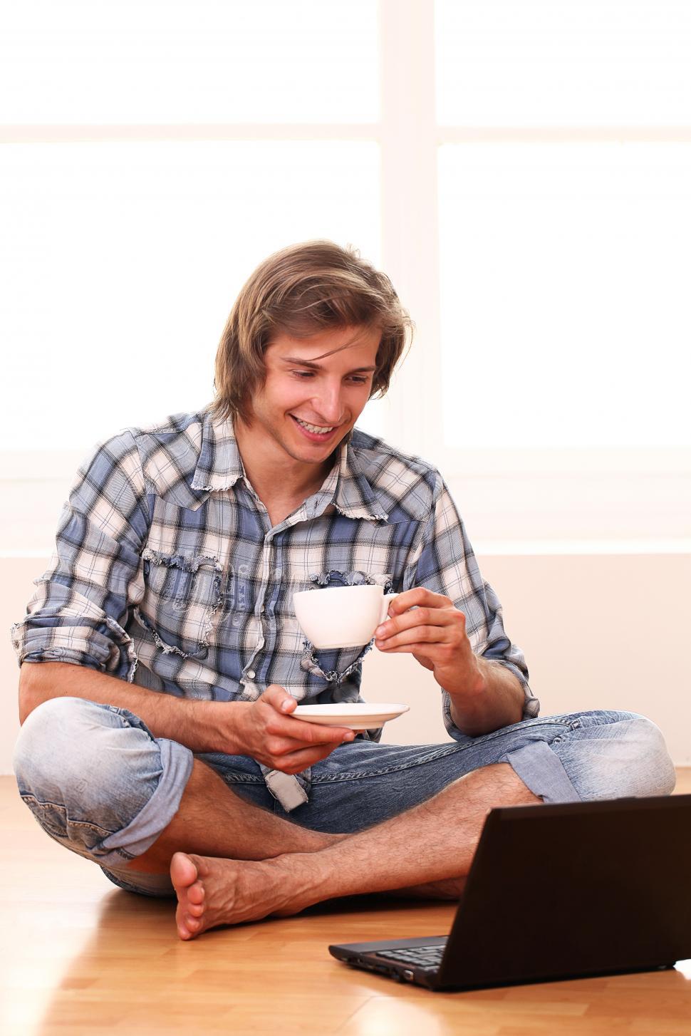 Free Image of Handsome guy with a cup of coffee and laptop 