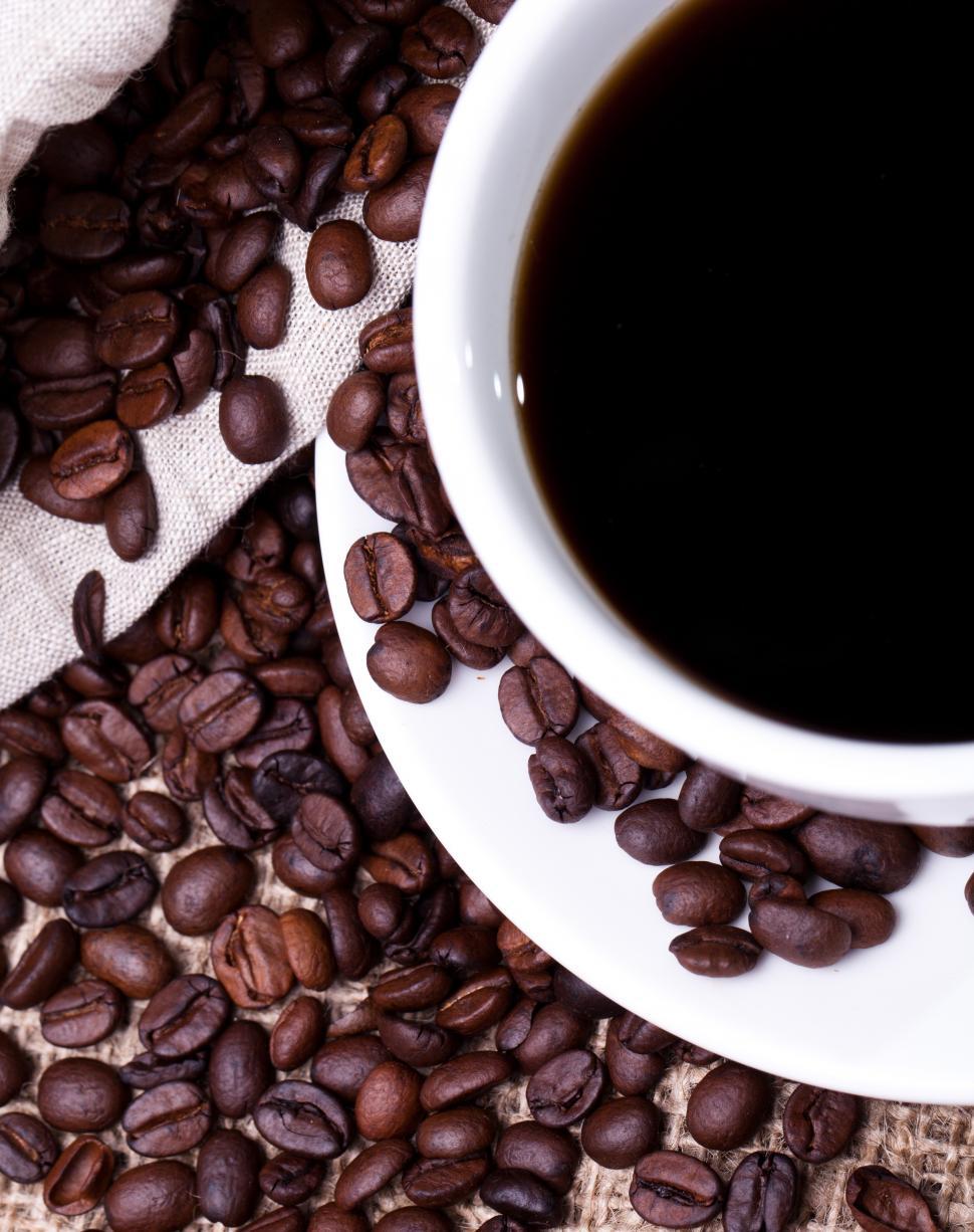 Download Free Stock Photo of Cup of hot coffee, looking down, with whole beans 