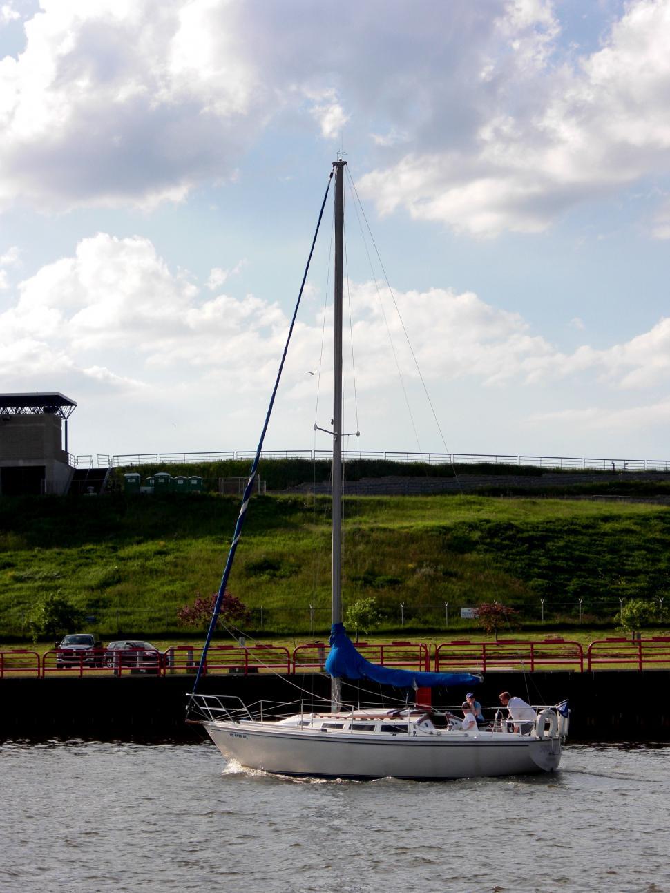 Free Image of A Sailboat Sailing Near a Dock 