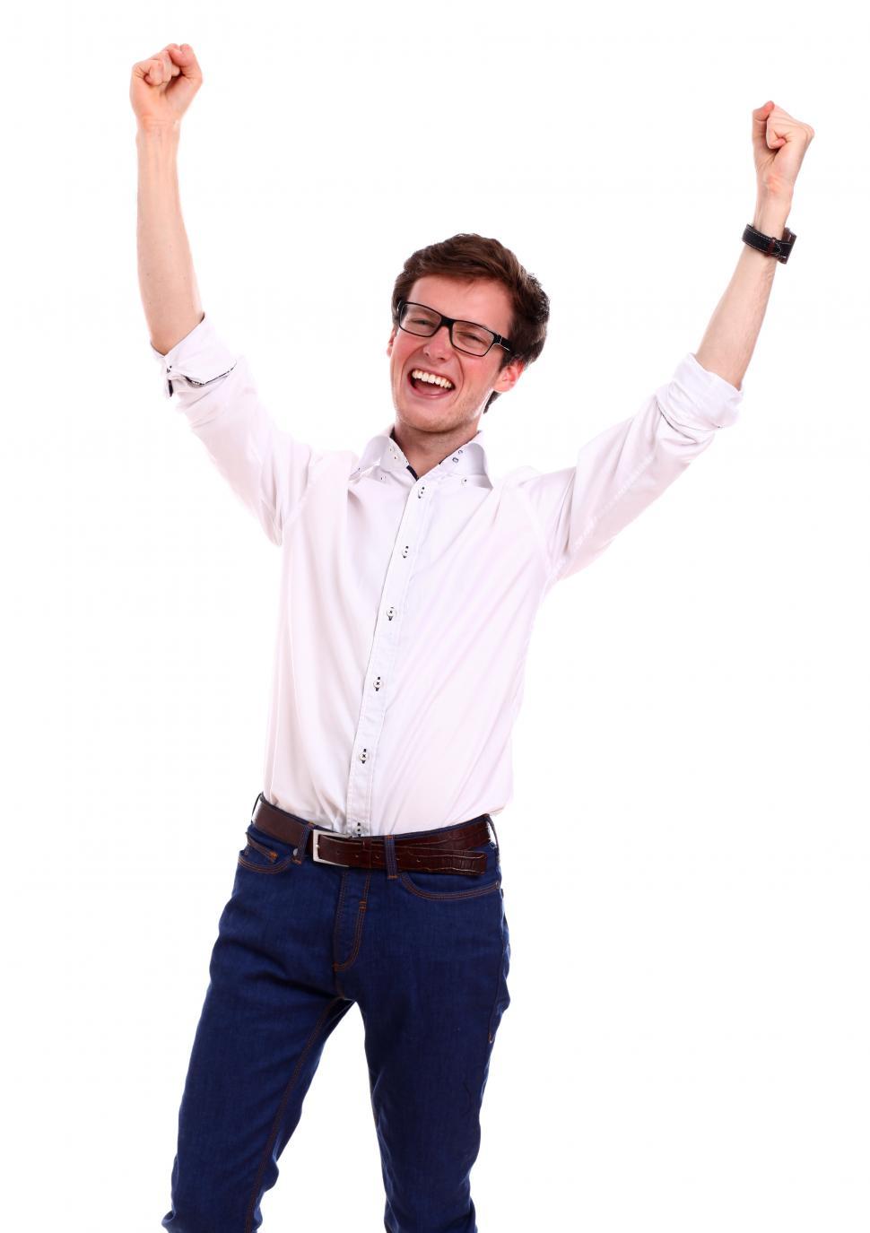 Free Image of Portrait of happy guy with arms raised in victory over white background 