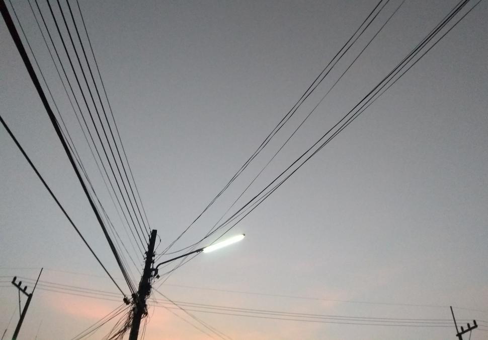 Free Image of Power lines and lit street light  