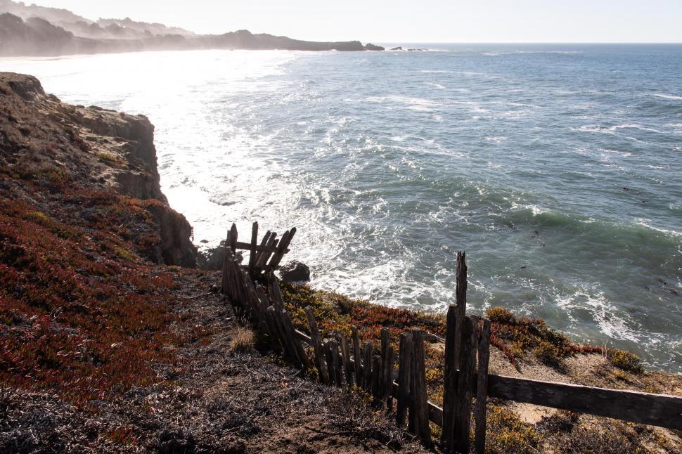 Free Image of Old worn fence along rugged shoreline 