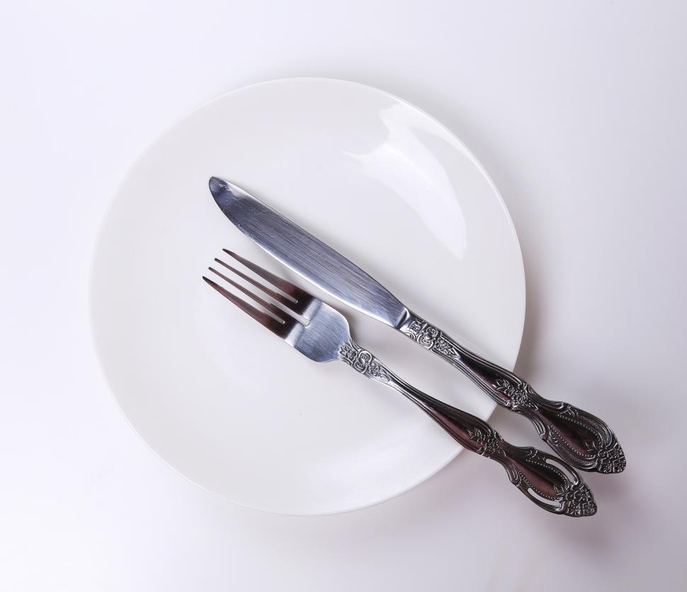 Free Image of Dining utensils on a white ceramic plate 
