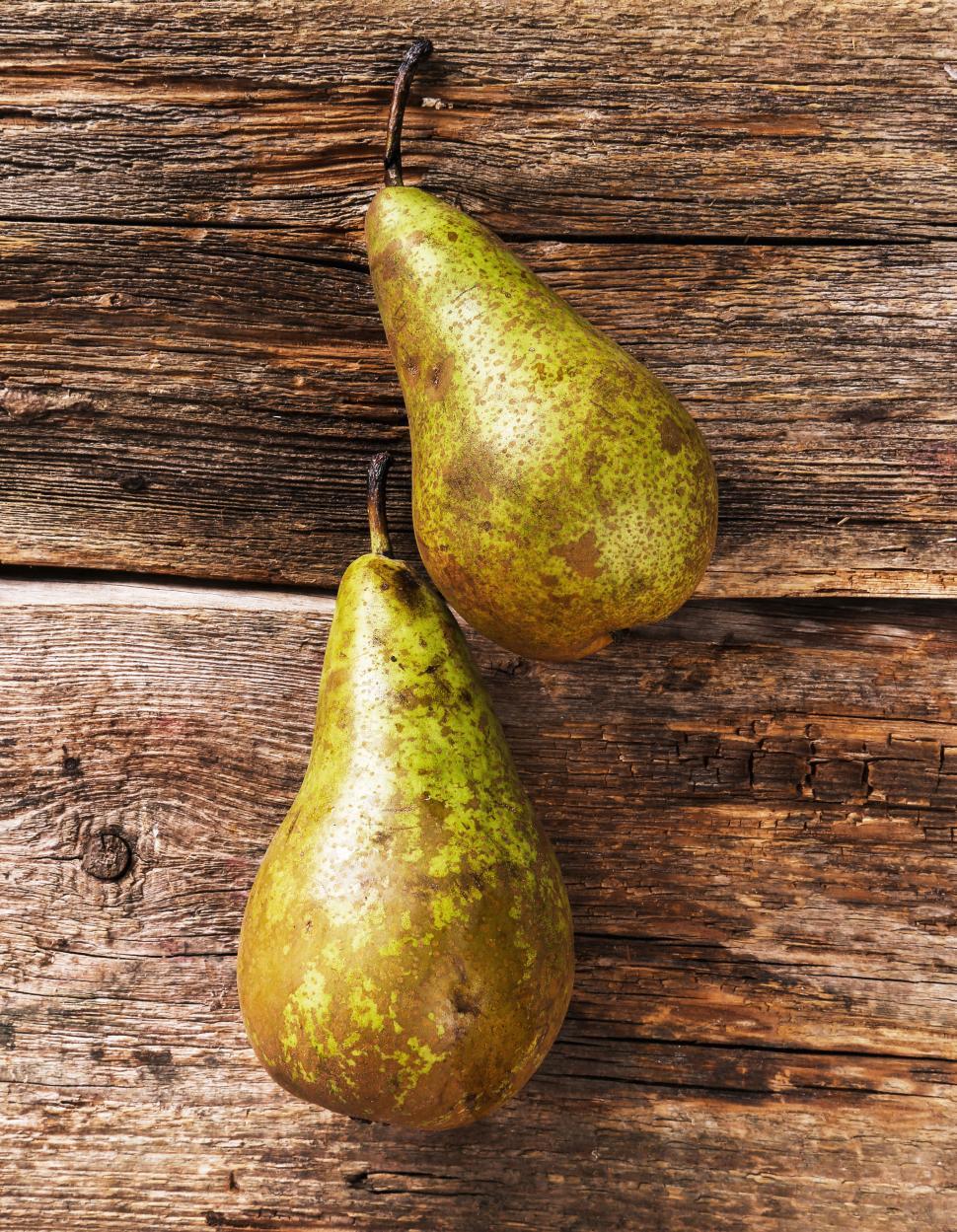 Free Image of Two delicious pears on textured wooden background 