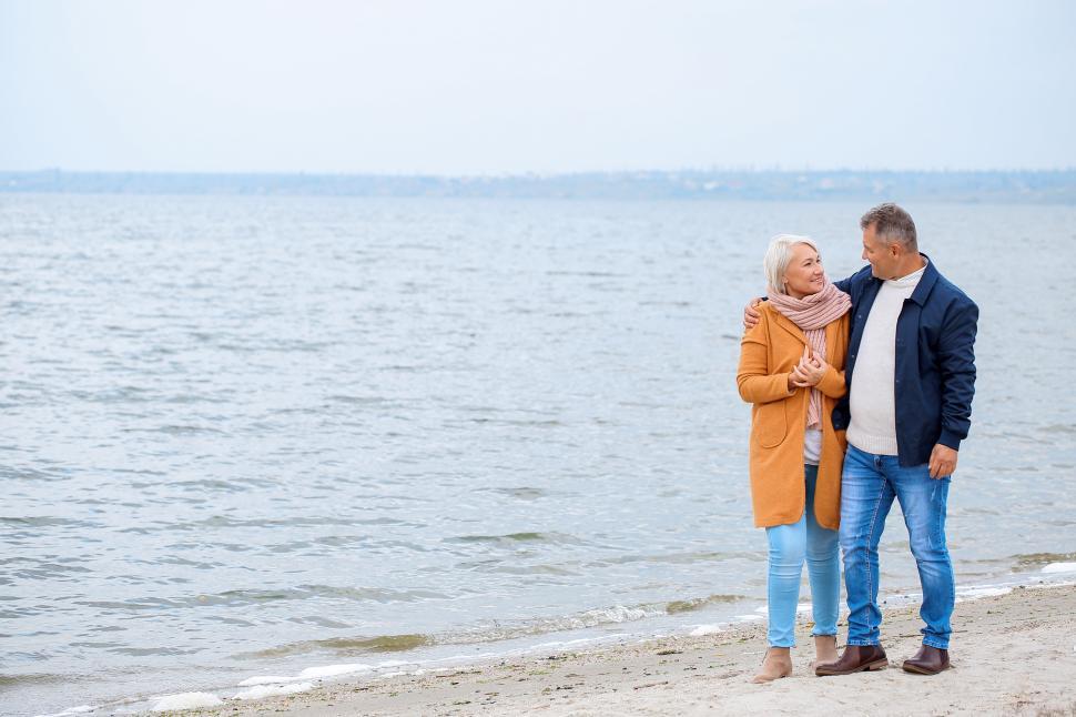 Free Image of Happy Couple in denim jeans and jacket walking at the beach - lo 
