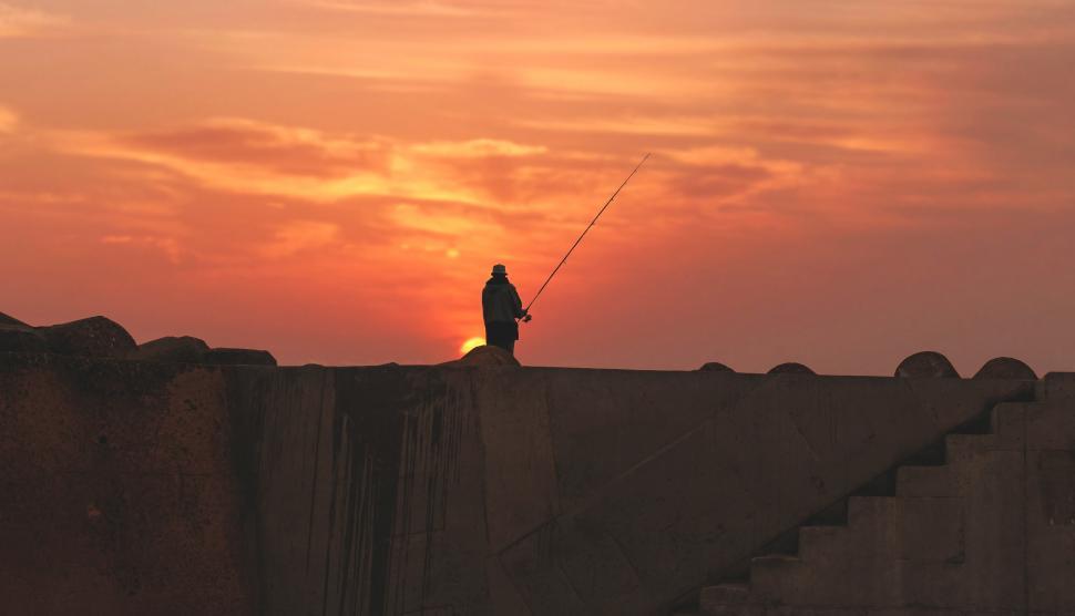 Free Image of Man and fishing rod with sunset 