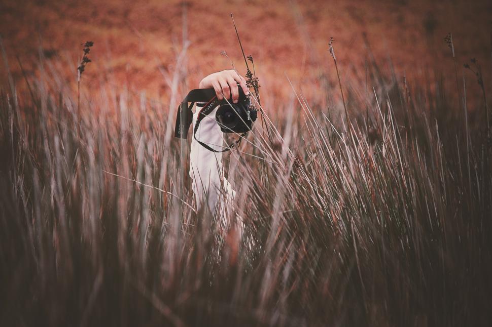 Free Image of Camera and hand with grass 