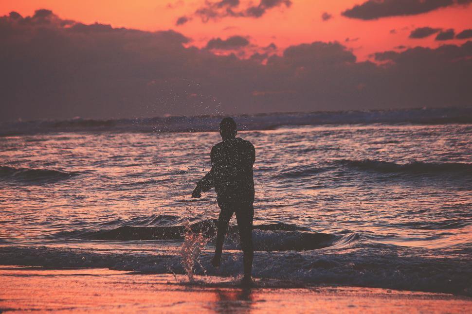 Free Image of Man playing at the beach during sunset 