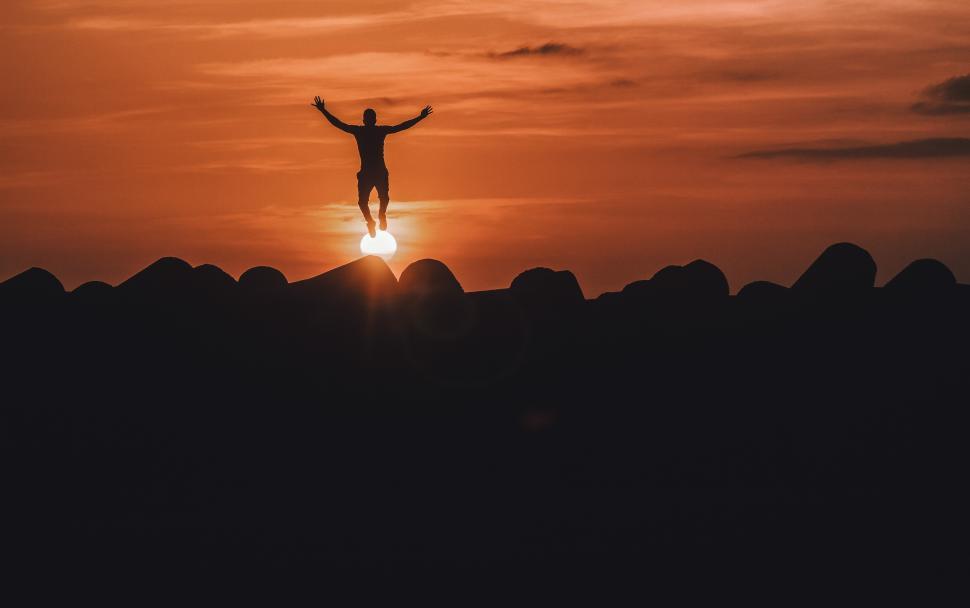 Free Image of Jumping in the air against sunset sky 