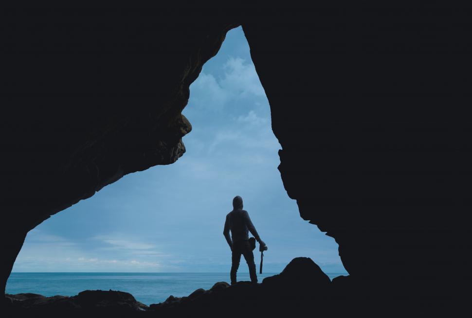 Free Image of Male photographer and mountain cave with blue sky 