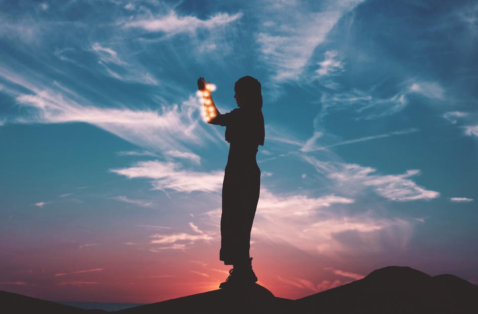 Free Image of Woman with burning fire lamps and sunset 