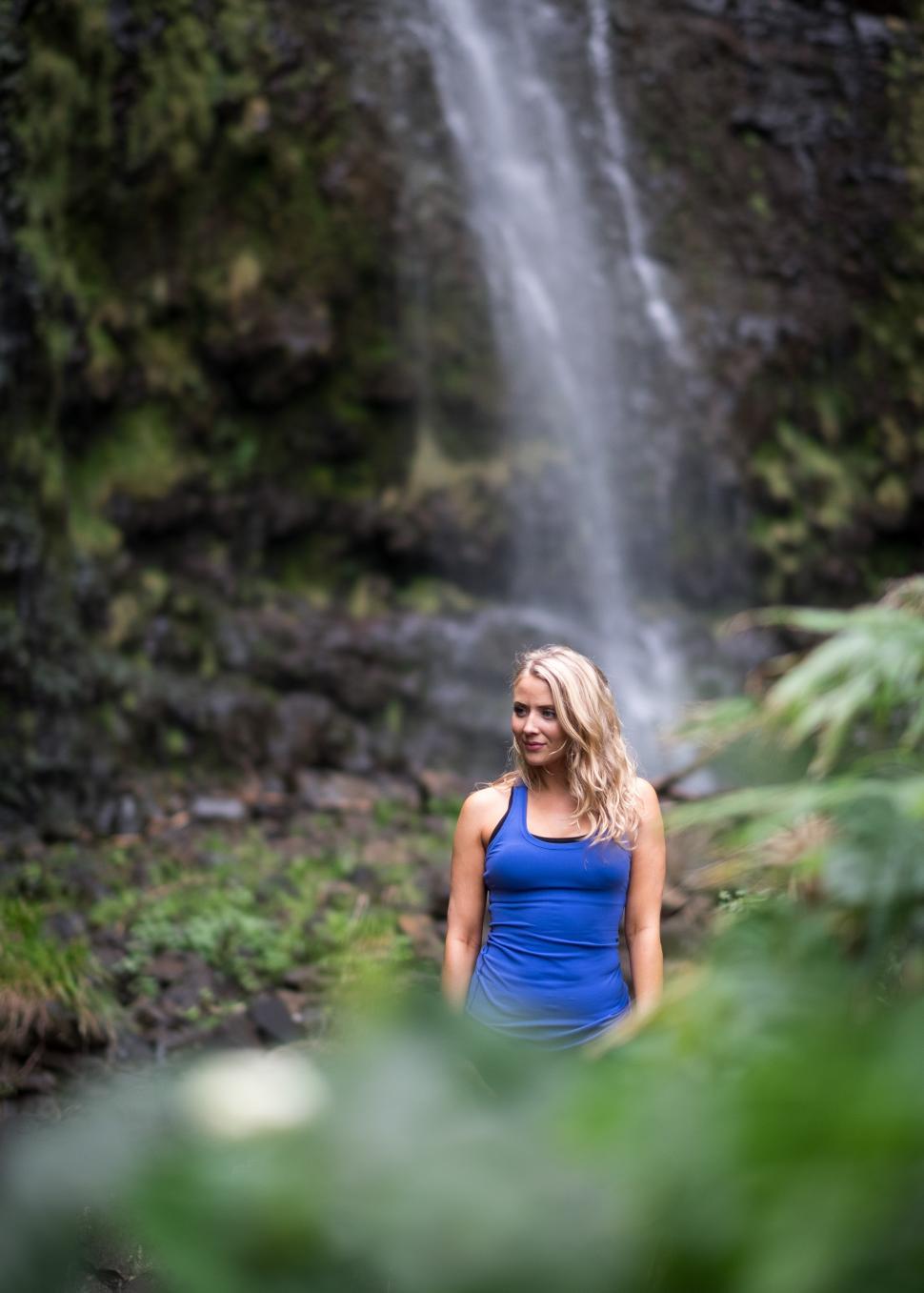 Free Image of Happy woman with waterfall and trees in the forest - looking awa 