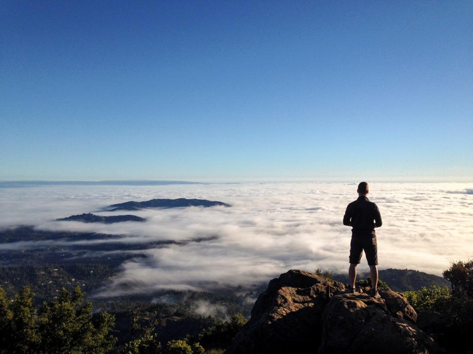 Free Image of Rear view of male hiker on mountain with clouds 