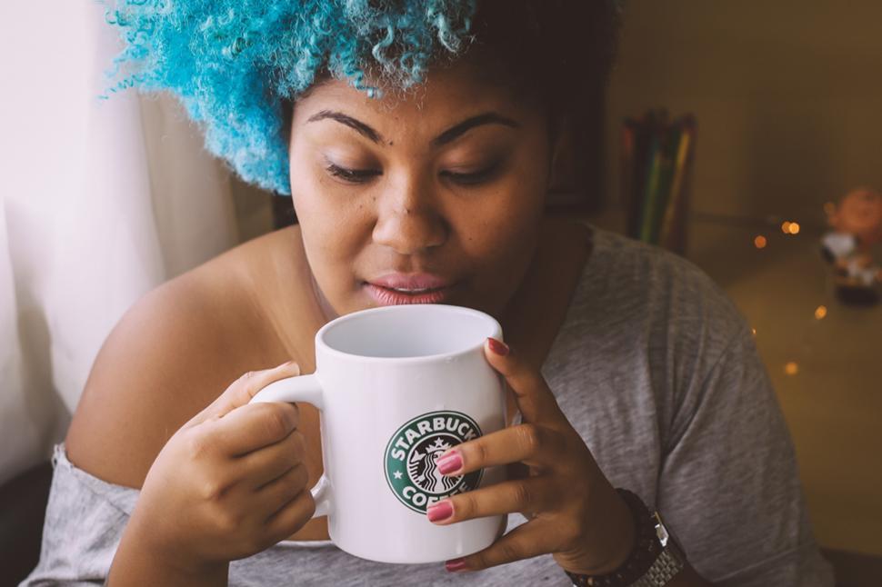 Free Image of Blue hair woman sipping coffee with mug 