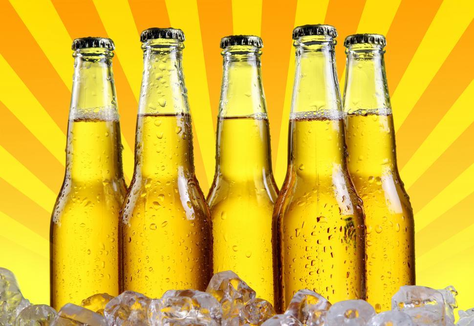Download Free Stock Photo of Bottles of beer with abstract burst graphic background 