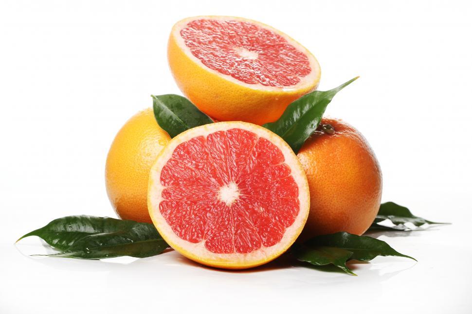 Free Image of Fresh grapefruits, halved and whole with leaves 