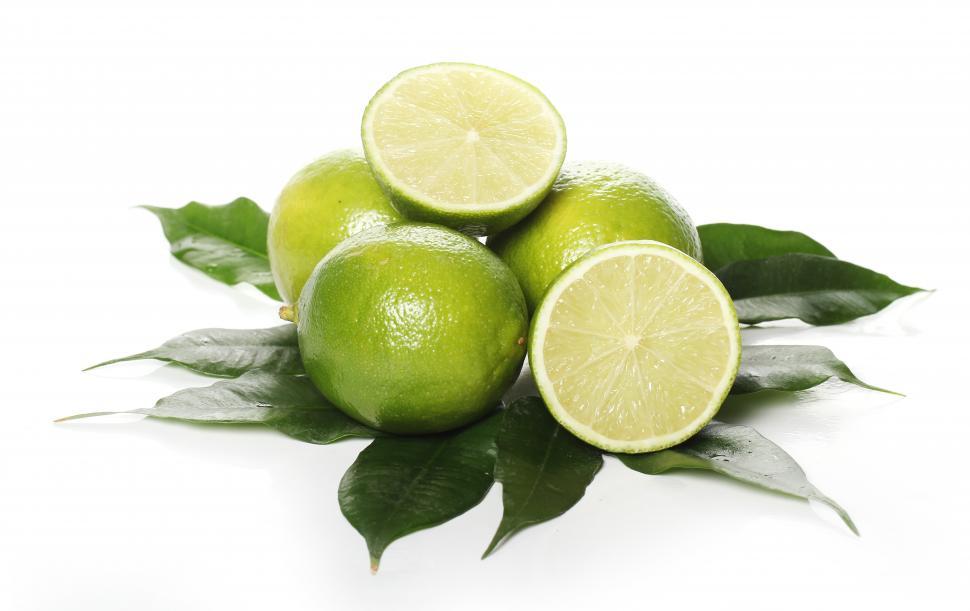 Free Image of Whole and cut fresh limes on green leaves 